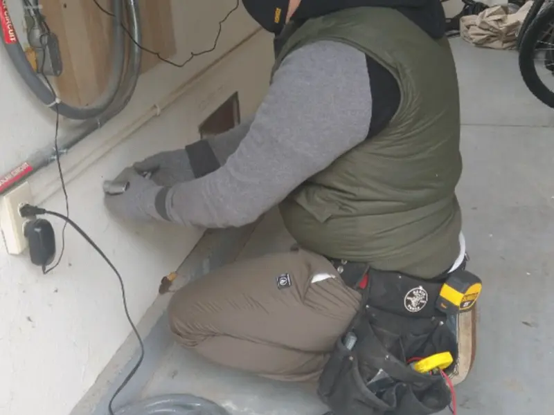 Electrician performing outlet wiring in a Midway garage